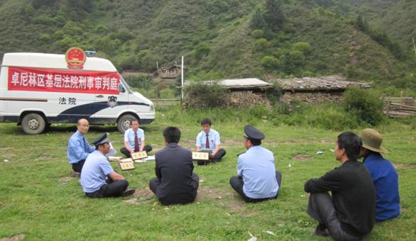 法官正在卓尼县尼巴乡达事尤沟才让某某家牧场里开庭审理才让某某盗伐