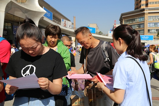宣传人员边讲解边给旅客送上宣传彩页n.jpg